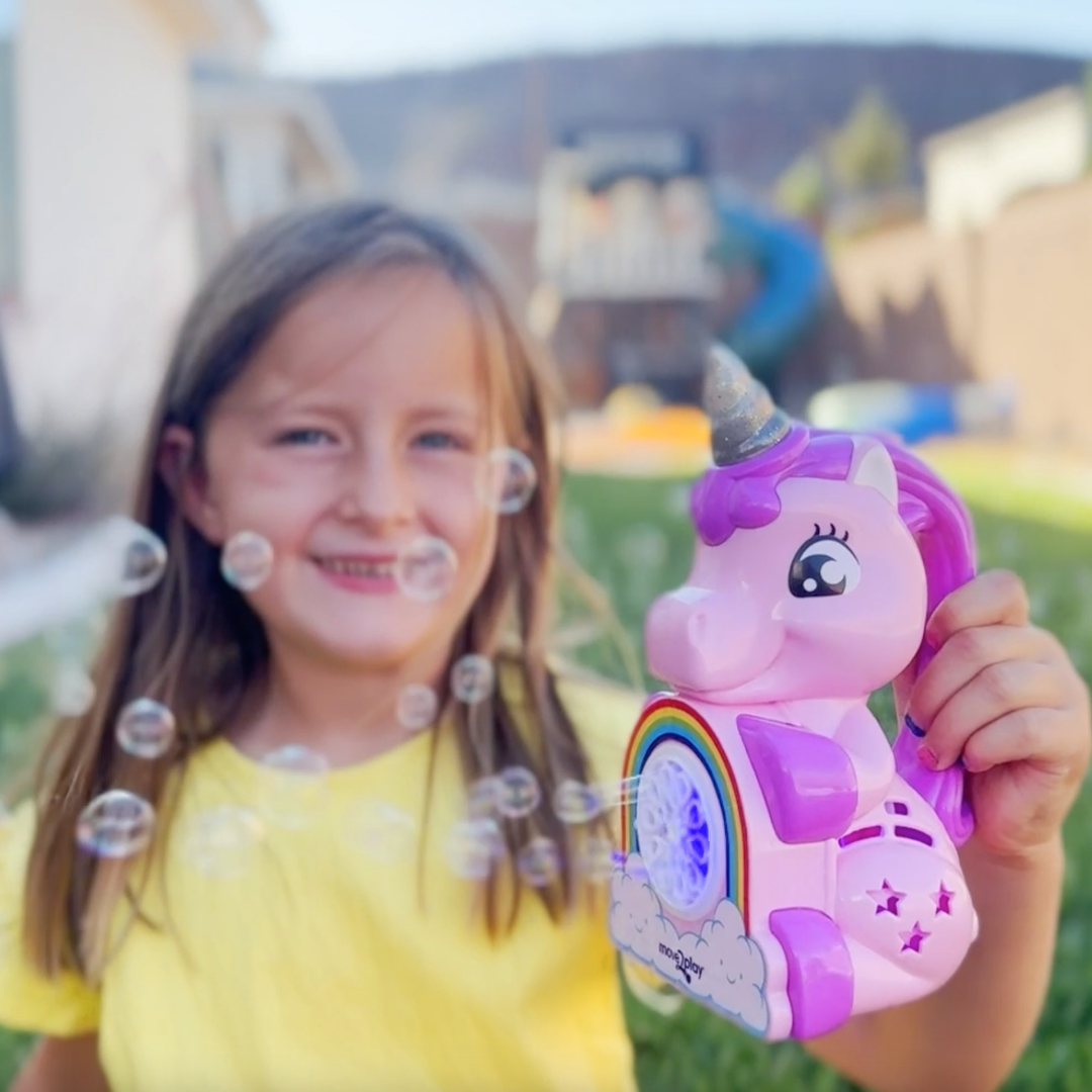 Child holding unicorn bubble blower toy with batteries and bubble solution included. Handheld design with durable, water-resistant features and easy-grip handle. Produces thousands of bubbles per minute for fun-filled occasions like birthdays and playdates.